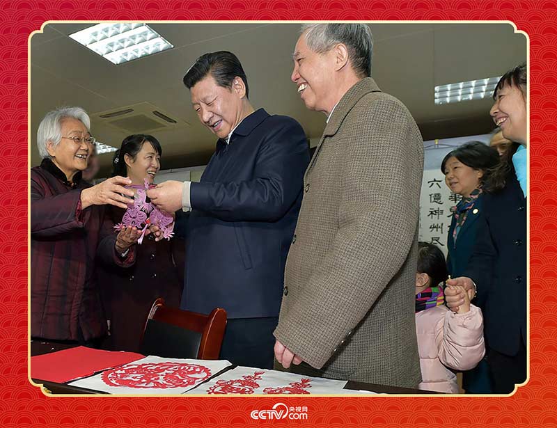 2015年2月15日，習近平在西安市雁塔區(qū)電子城街道二〇五所社區(qū)服務(wù)中心欣賞社區(qū)居民的剪紙作品。