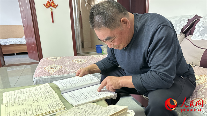 青格達(dá)湖鄉(xiāng)天山村村民李強(qiáng)拿出近幾年的賬本查看。人民網(wǎng)記者 楊睿攝