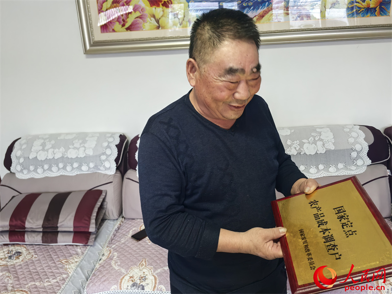 李強(qiáng)向記者展示他獲得的“國家定點(diǎn)農(nóng)產(chǎn)品成本調(diào)查戶”牌匾。人民網(wǎng)記者 陳新輝攝
