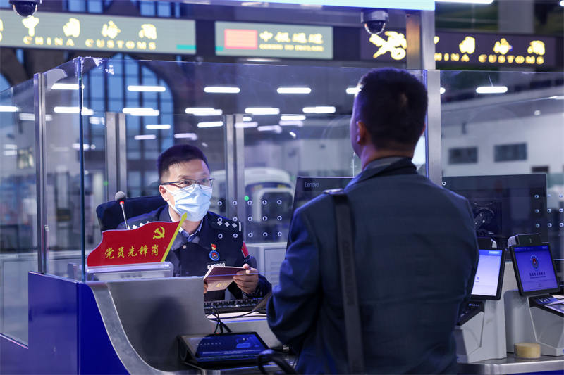 圖為霍爾果斯出入境邊防檢查站民警為入境游客辦理邊檢手續(xù)。宋唯一攝